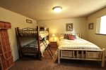 Second bedroom with queen bed and set of bunk beds in Sisters Vacation Cabin